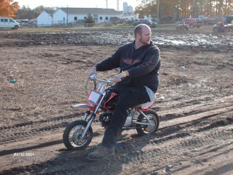 1995 Ford Probe - A man rides a dirt bike through a muddy outdoor area.