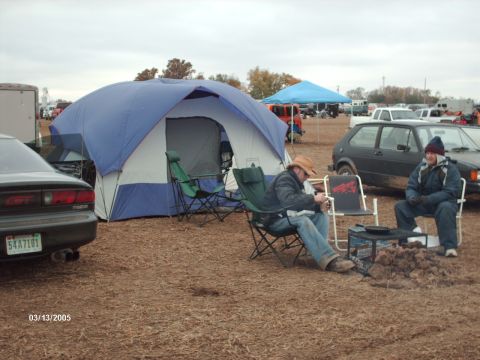 1995 Ford Probe - A black car is parked next to a large tent at an outdoor event.