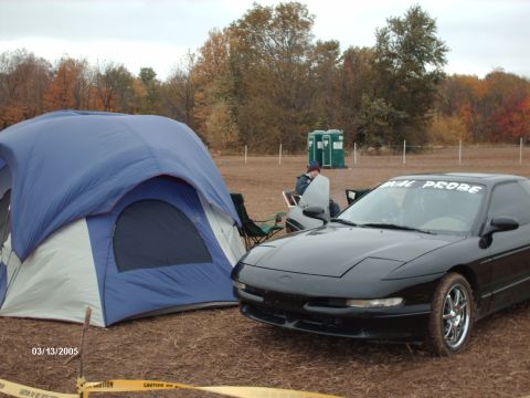 1995 Ford Probe - Black 1995 Ford Probe with 'FINAL PROBE' banner on windshield, parked near a tent.
