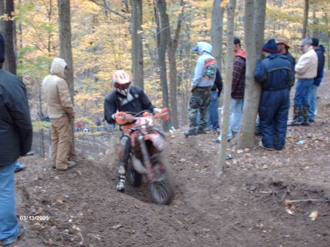 1995 Ford Probe - A dirt bike rider navigates a muddy course through a wooded area.