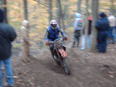 1995 Ford Probe - A dirt bike rider navigates a muddy course through a wooded area.