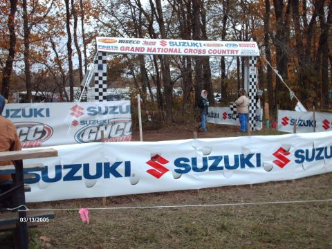 1995 Ford Probe - A cross country race finish line is set up with sponsor banners and checkered flags.