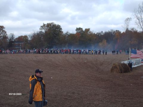 1995 Ford Probe - A large group of motorcycles are lined up at the start of a motocross race, with an American flag visible on the right side of the frame.