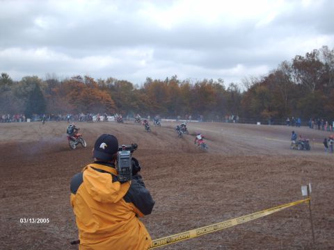 1995 Ford Probe - A motocross race event is captured on camera with riders competing on a dirt track under an overcast sky.
