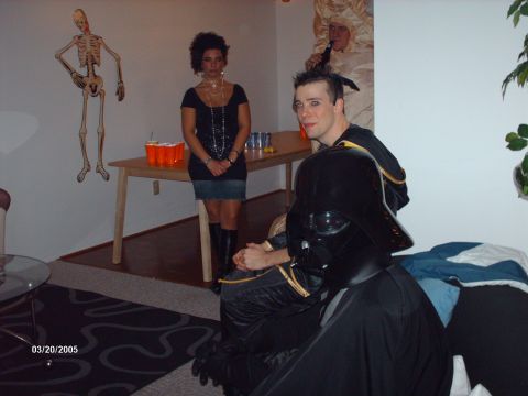 1995 Ford Probe - A group of people in costumes are gathered at a party, with a skeleton decoration on the wall and drinks on a table.