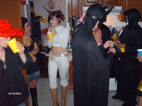 1995 Ford Probe - Partygoers in costumes mingle while holding drinks, with a date stamp of 03/20/2005 visible.
