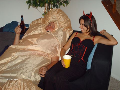 1995 Ford Probe - Two people in Halloween costumes relax on a couch, one holding a beer and the other a drink.