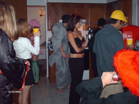 1995 Ford Probe - Partygoers in various costumes gather indoors, with some holding drinks and snacks.