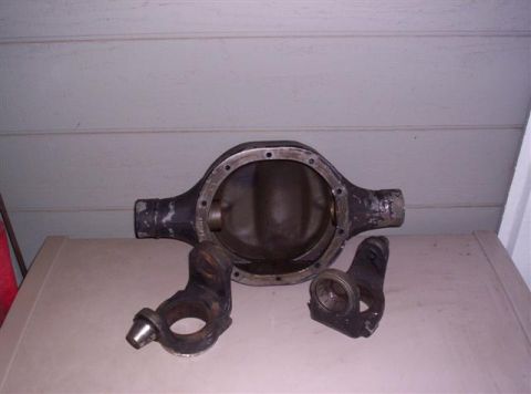 1995 Ford Bronco - A disassembled rear axle differential housing and associated knuckle components are displayed on a surface.
