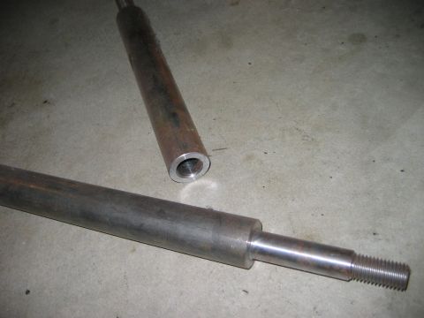 1985 Ford Bronco - Two metal shafts are shown on a concrete surface, with one piece a threaded end.