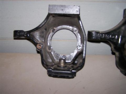 1995 Ford Bronco - Two cast metal parts, possibly steering knuckles, are shown in a close-up view.