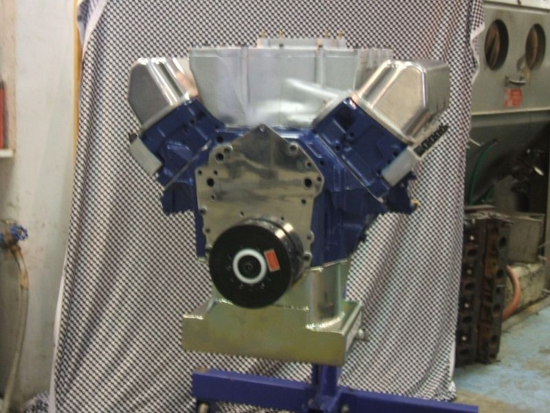 V8 engine block with blue painted valve covers on an engine stand