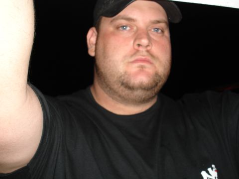 1989 Ford Bronco - Close-up of a man wearing a black t-shirt and baseball cap with a Supermotors logo.