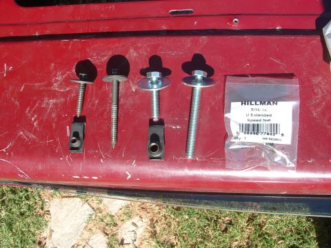 1990 Ford Bronco - Hardware for a vehicle repair, including speed nuts and bolts, laid out on a red surface.