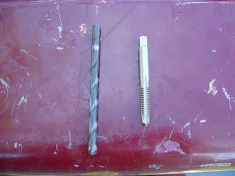1990 Ford Bronco - Drill bit and tap shown side-by-side on a red surface.