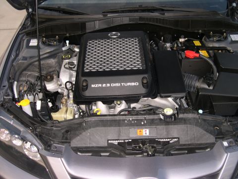 1997 Ford Probe - The engine bay of a gray vehicle is shown with the hood open, revealing the "MZR 2.3 DISI TURBO" engine cover.