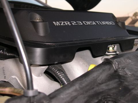 1997 Ford Probe - Close-up of an engine cover displaying "MZR 2.3 DISI TURBO" lettering.