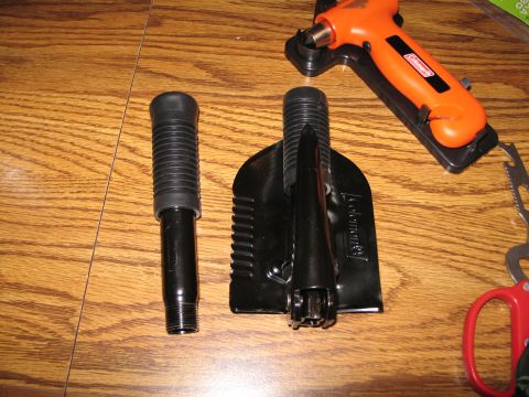 1995 Ford Bronco - A collection of outdoor tools including a shovel, a multi-tool, and scissors are laid out on a wooden table.