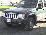1984 Ford Bronco - This Jeep Grand Cherokee is parked outdoors, showing its front grille and headlights.