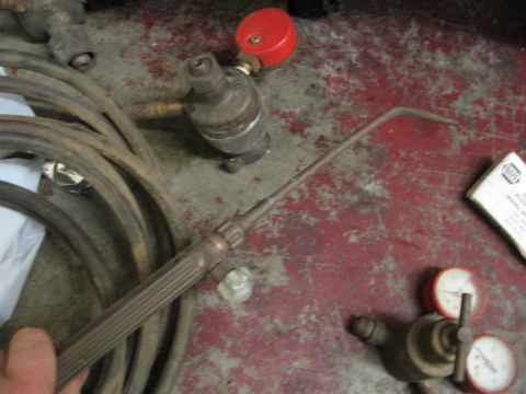 1974 Ford F-100 - Welding equipment including a torch, hoses, and pressure regulators are laid out on a floor.