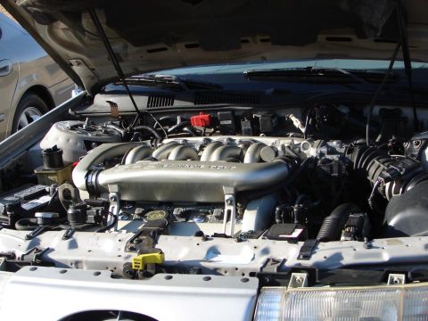 1992 Ford Taurus - The 3.0L V6 engine of a 1992 Ford Taurus is visible with the hood open, the prominent intake manifold.