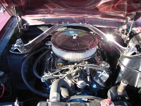 1992 Ford Taurus - Close-up of a vehicle's engine bay, a chrome Edelbrock air cleaner and a polished strut tower brace.