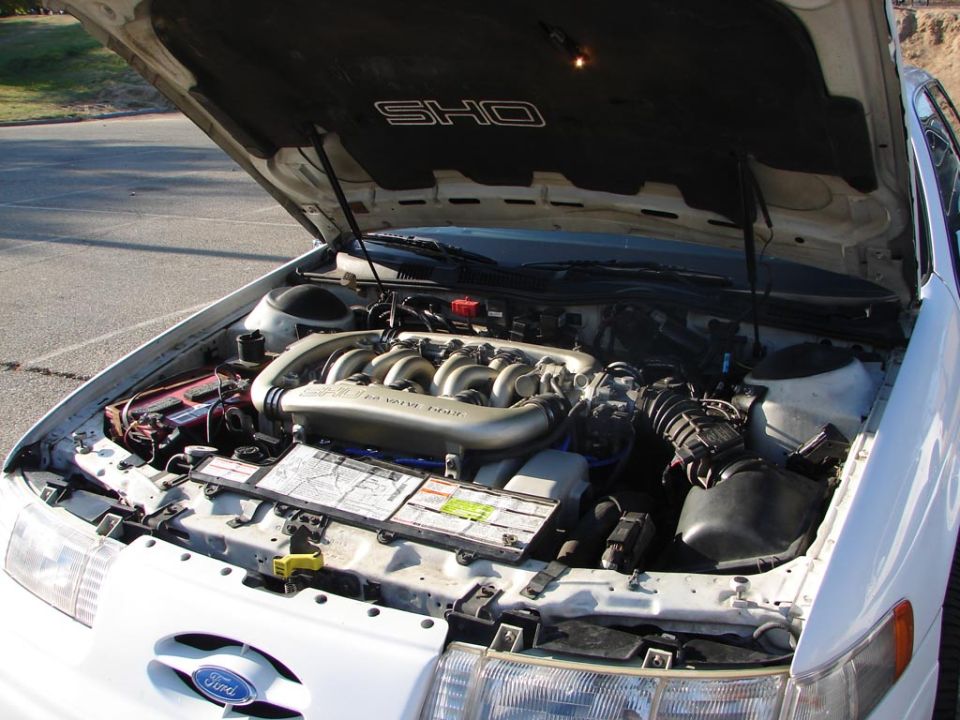 White 1992 Ford Taurus SHO engine bay with hood open, showing V6 engine and SHO badging on hood liner