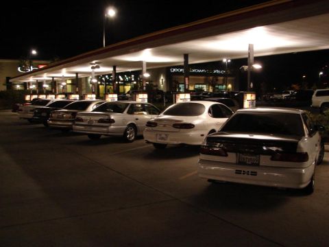 1992 Ford Taurus - Several sedans are parked under a covered area at night, with a white sedan in the foreground.