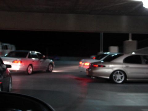 1992 Ford Taurus - Several sedans are visible in this nighttime shot, with one silver car custom wheels.
