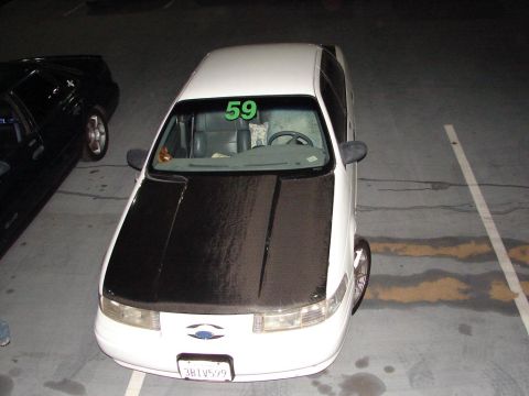 1992 Ford Taurus - White 1992 Ford Taurus parked next to a black car, displaying racing number 59.