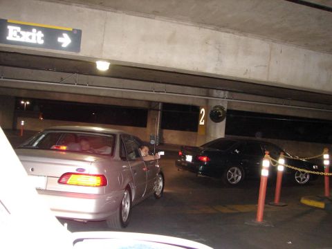 1992 Ford Taurus - Two sedans are parked in a dimly lit parking garage, with an exit sign visible above.