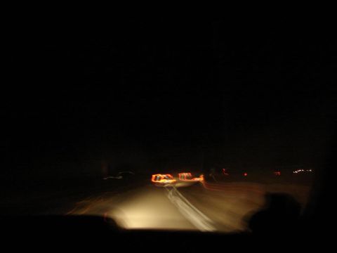 1992 Ford Taurus - Nighttime scene with blurred vehicle lights on a road, indicating motion and distance.