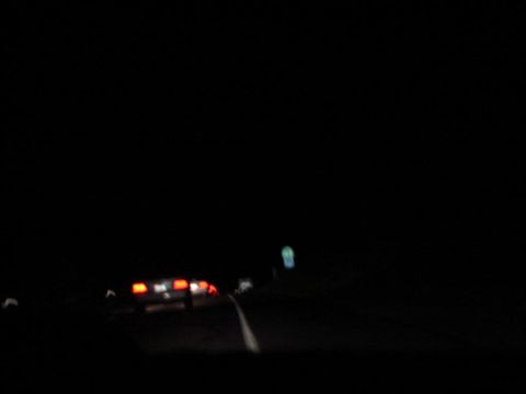 1992 Ford Taurus - Rear view of a 1992 Ford Taurus at night, showing its taillights illuminated.