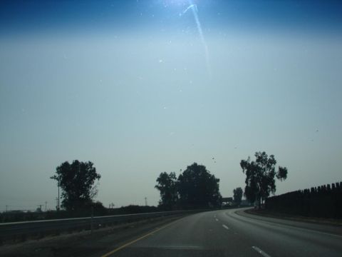 1992 Ford Taurus - Driving on a highway with trees and a fence lining the road.