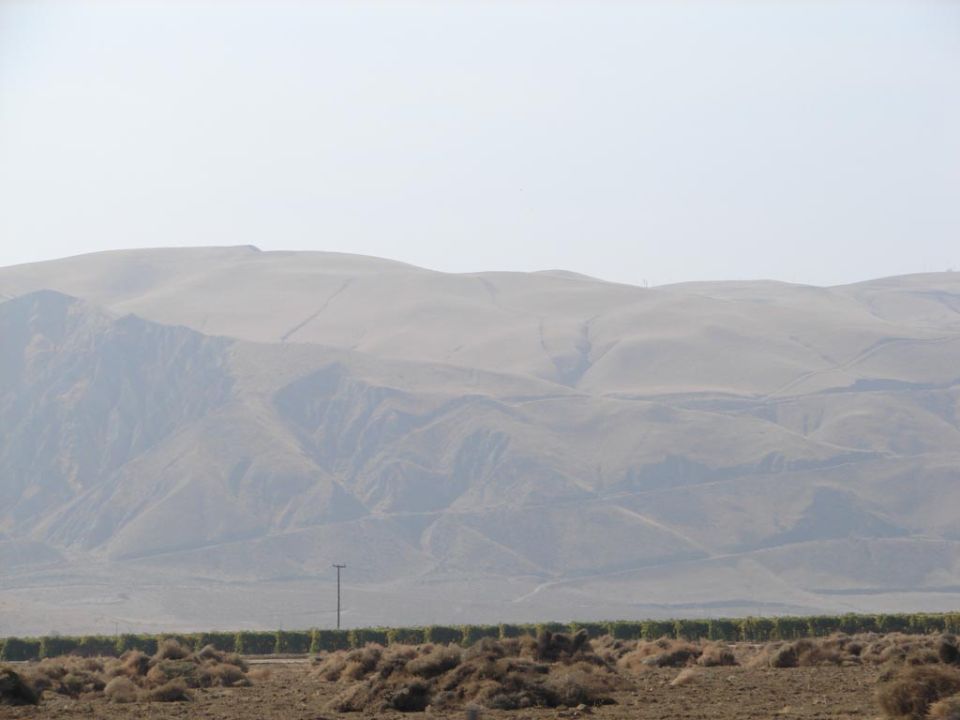 hazy mountain landscape with dry brush and a utility pole