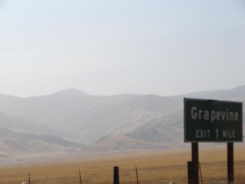 1992 Ford Taurus - A sign indicates the Grapevine exit is one mile away, with hazy mountains in the background.