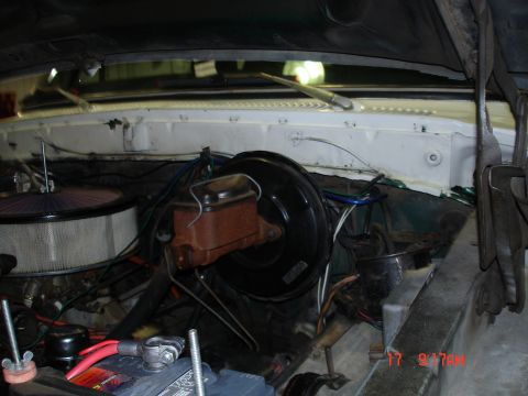 1979 Ford Bronco - The engine bay of a vehicle shows various components including the brake booster, master cylinder, air filter, and battery.