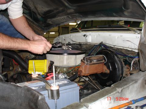 1979 Ford Bronco - A mechanic works on the engine of a 1979 Ford Bronco, focusing on the carburetor and air filter assembly.
