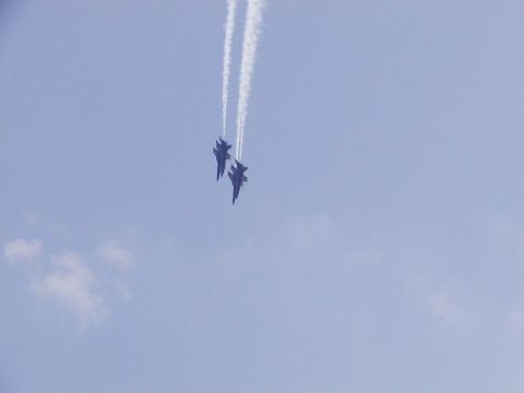1998 Ford Taurus - Two fighter jets perform aerobatics, leaving white contrails against a clear blue sky during an airshow.