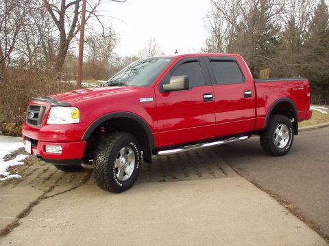 1994 Ford Bronco - This red Ford F-150 pickup truck is shown from a three-quarter front view on a cloudy day.