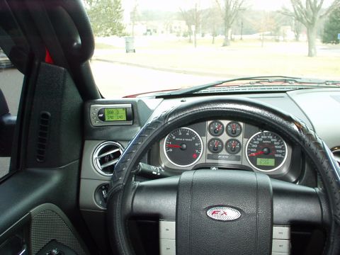 1994 Ford Bronco - The interior of a red Ford F-150 shows the dashboard with a digital gauge and FX4 badging on the steering wheel.
