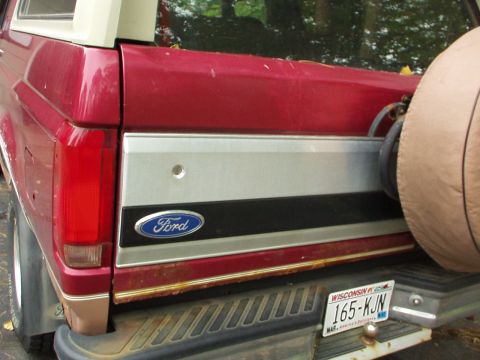1994 Ford Bronco - The rear of a red 1994 Ford Bronco shows its spare tire and a Wisconsin license plate.