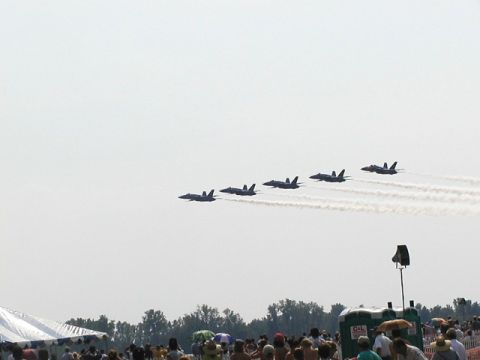 1998 Ford Taurus - A formation of fighter jets performs at an airshow, with spectators gathered below.