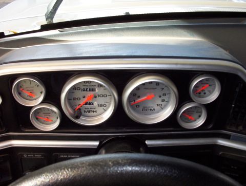 1987 Ford Bronco - Close-up of a vehicle's interior dashboard, a set of custom gauges.