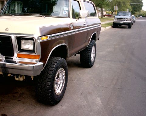 1979 Ford Bronco - A two-tone brown and tan Ford Bronco is parked on the street, with another vehicle in the background.