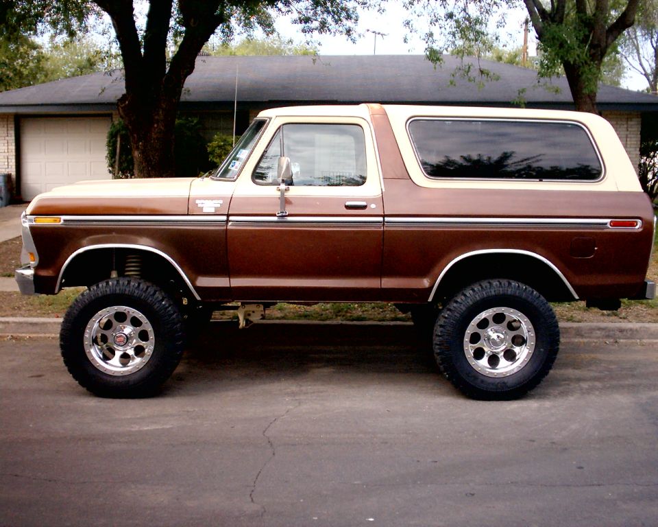 Brown and cream 1978 Ford Bronco with lifted suspension and aftermarket wheels parked on a street