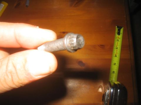 1979 Ford Bronco - A bolt is measured with a tape measure, indicating a length of approximately 2 inches.