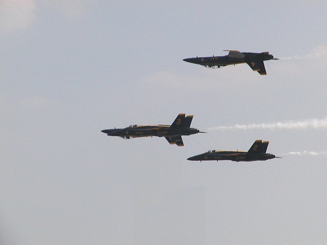 Three fighter jets flying in formation against a clear sky