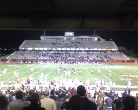2000 Ford Crown Victoria - A football game is underway in a stadium filled with spectators.