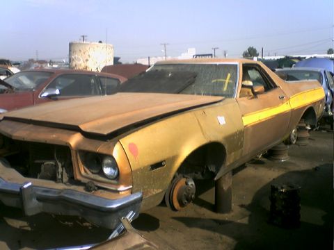1973 Ford Ranchero - This 1973 Ford Ranchero, sporting a two-tone gold and brown paint scheme with a yellow stripe, sits on blocks in a junkyard.